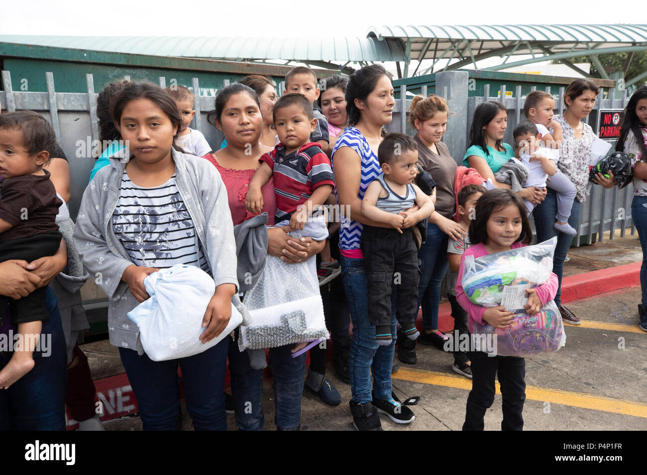 Immigrant mothers, wearing electronic monitoring devices, and their young children captured coming across the United States-Mexico border in Texas are released at a bus station in McAllen. The families will travel to stay with family members in the U.S. while awaiting deportation or asylum hearings. Stock Photo