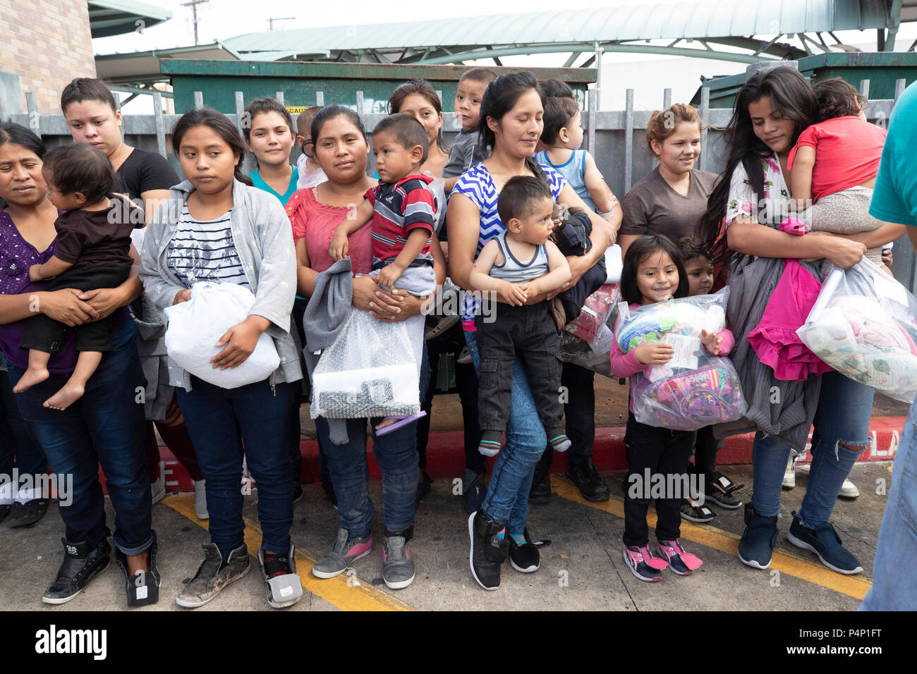 Immigrant mothers, wearing electronic monitoring devices, and their young children captured coming across the United States-Mexico border in Texas are released at a bus station in McAllen. The families will travel to stay with family members in the U.S. while awaiting deportation or asylum hearings. Stock Photo