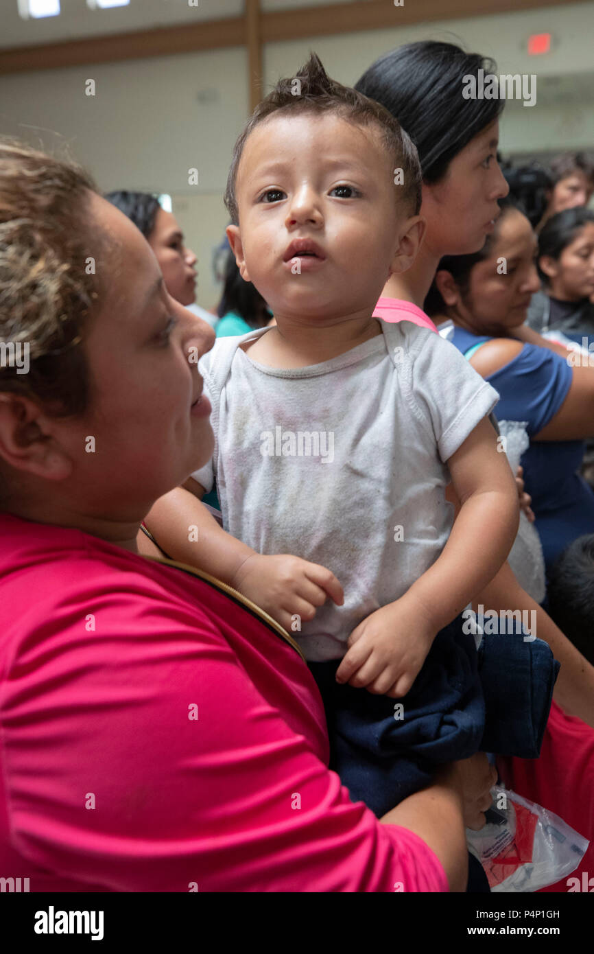 Immigrant mothers, wearing electronic monitoring devices, and their young children captured coming across the United States-Mexico border in Texas are released at a bus station in McAllen. The families will travel to stay with family members in the U.S. while awaiting deportation or asylum hearings. Stock Photo