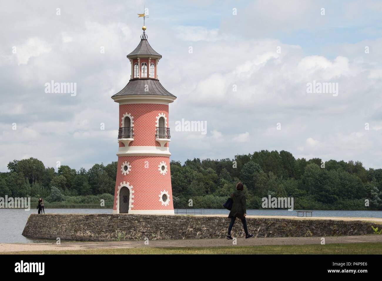 Moritzburg, Germany. 22nd June, 2018. A woman walks along a jetty in front of the lighthouse. Credit: Sebastian Kahnert/dpa-Zentralbild/ZB/dpa/Alamy Live News Stock Photo