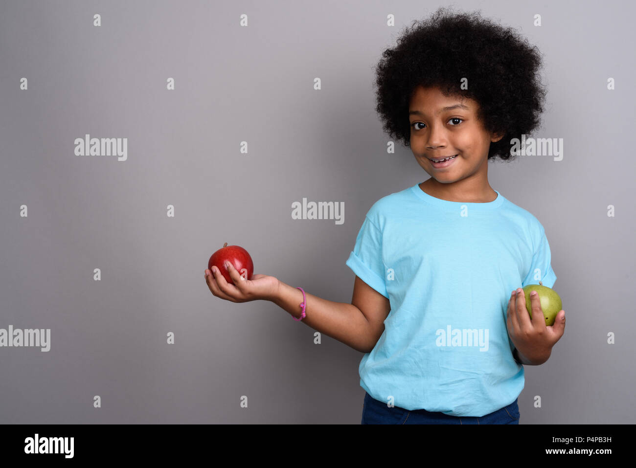 Young cute African girl against gray background Stock Photo