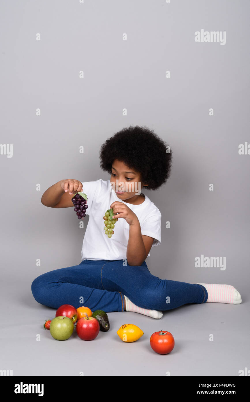 Young cute African girl against gray background Stock Photo