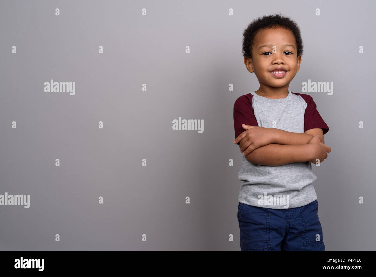 Young cute African boy against gray background Stock Photo