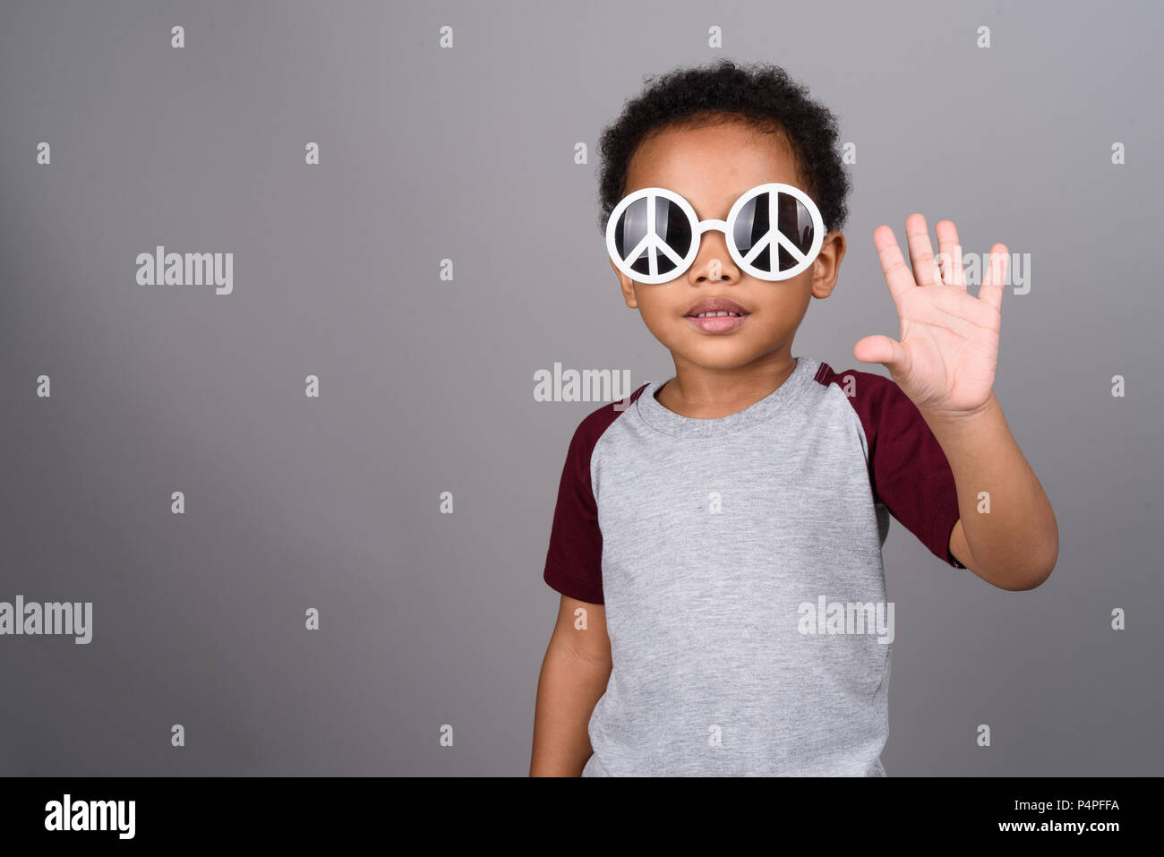 Young cute African boy against gray background Stock Photo