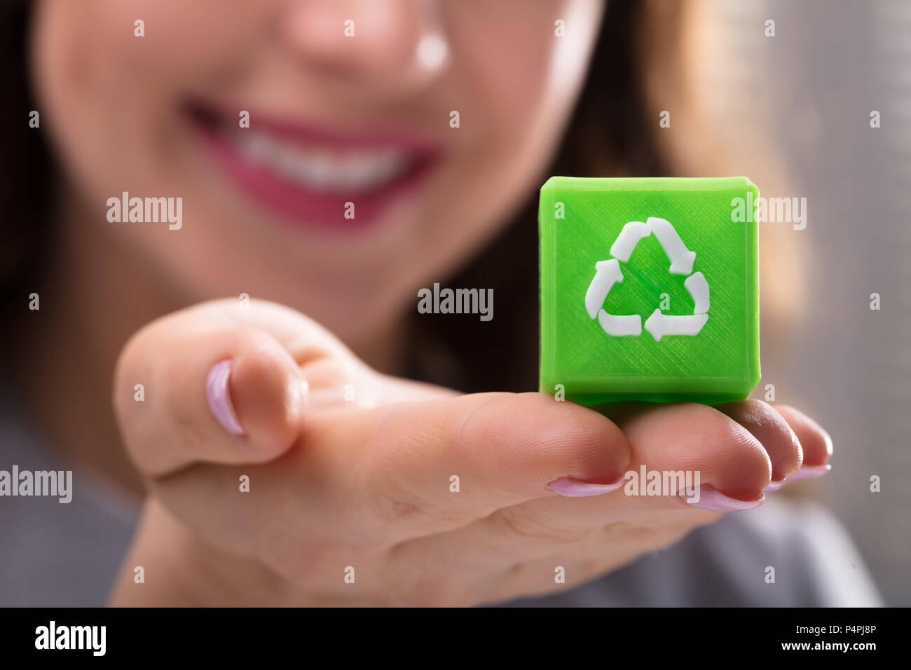 Close-up Of A Woman's Hand Holding Green Cubic Block With Recycle Symbol Stock Photo