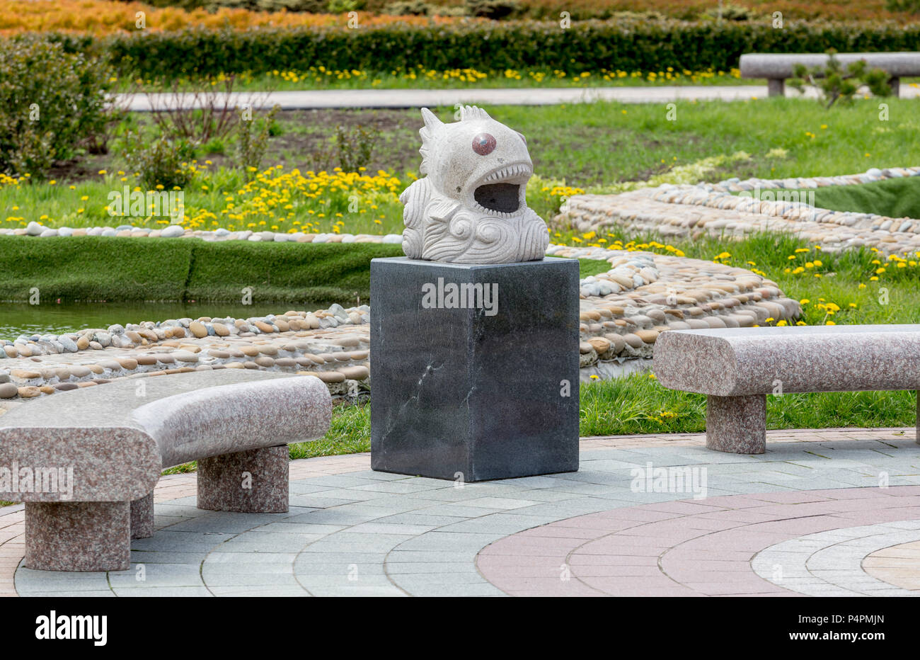 Russia, Vladivostok, 05/26/2018. Stylish benches and trash can in a form of fish in a amusement park of Oceanarium on Russky Island. Nice meadow on a  Stock Photo
