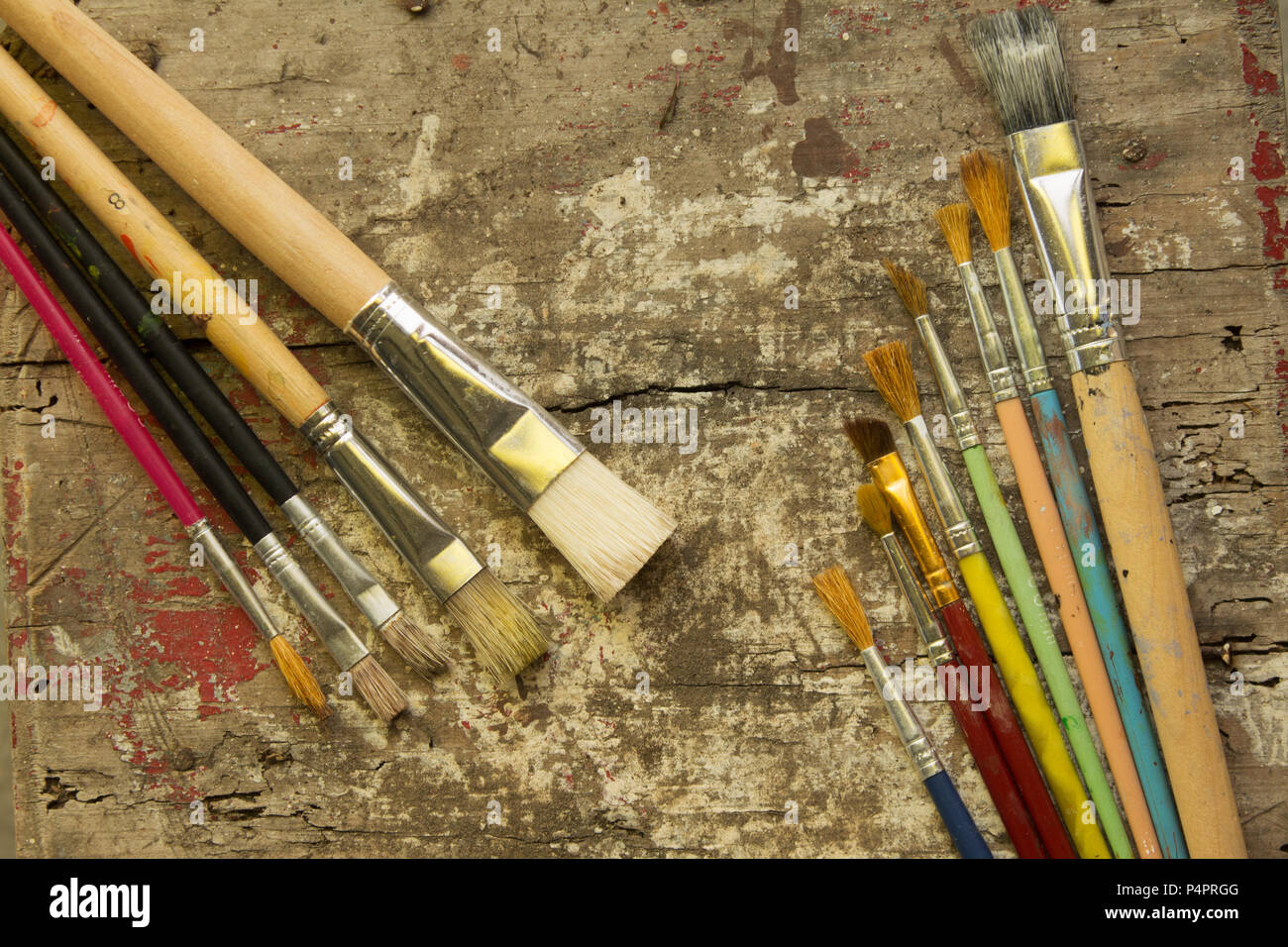different size paint brushes on a rustic wood table, artist workshop Stock Photo