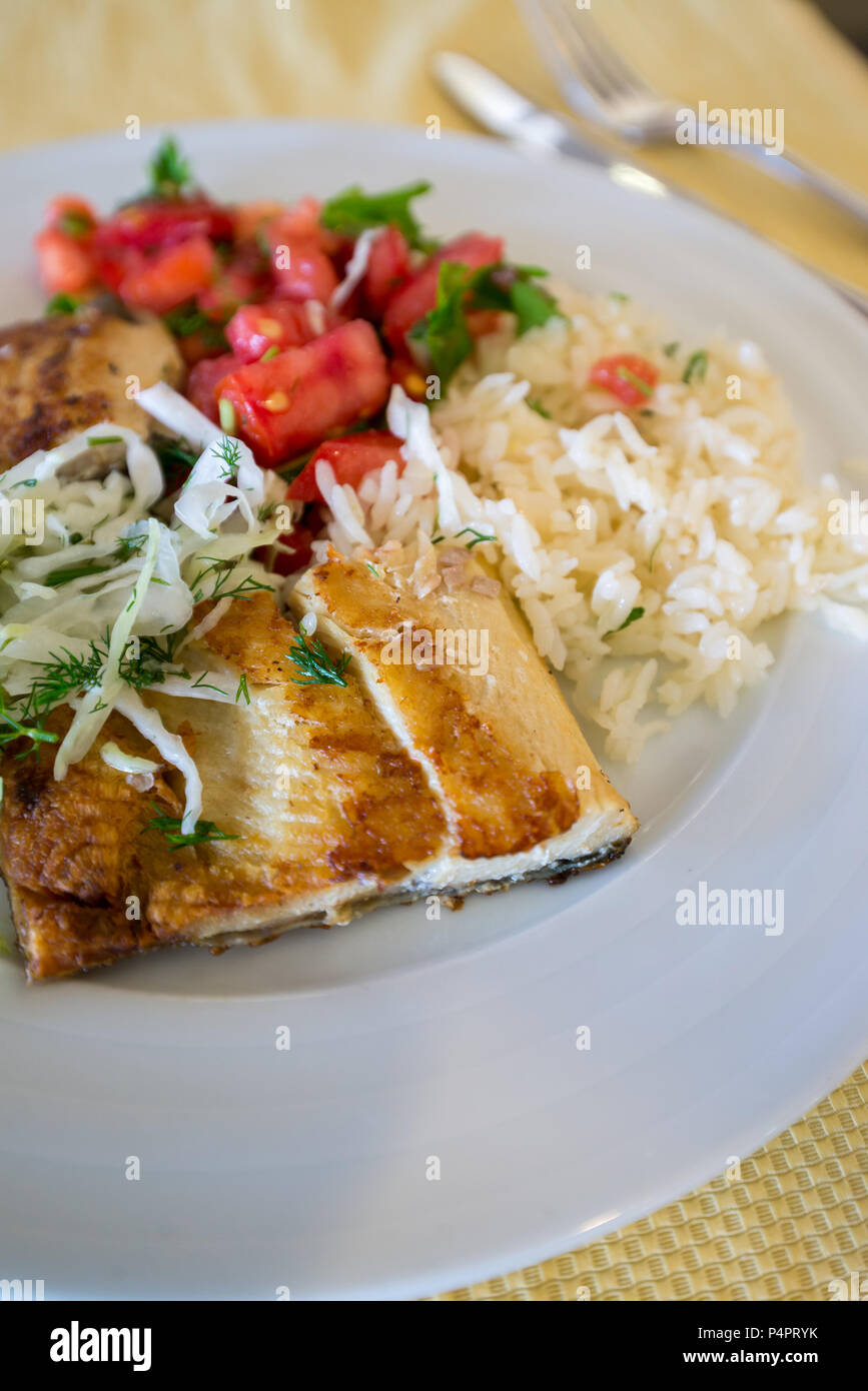 fried fish with rice cabbage and tomatoes on plate Stock Photo