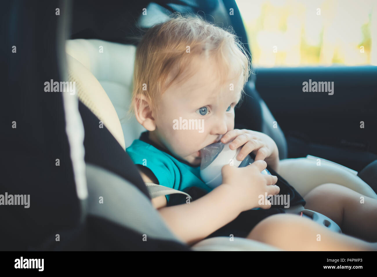 The child is fastened with seat belts, sitting in a child seat in the