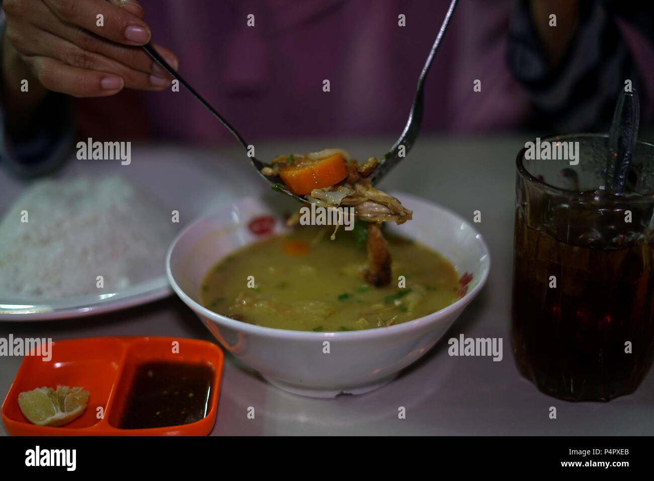 Delicious Nasi Soto, the Traditional Indonesian Food Served with Rice and Ice Tea Stock Photo