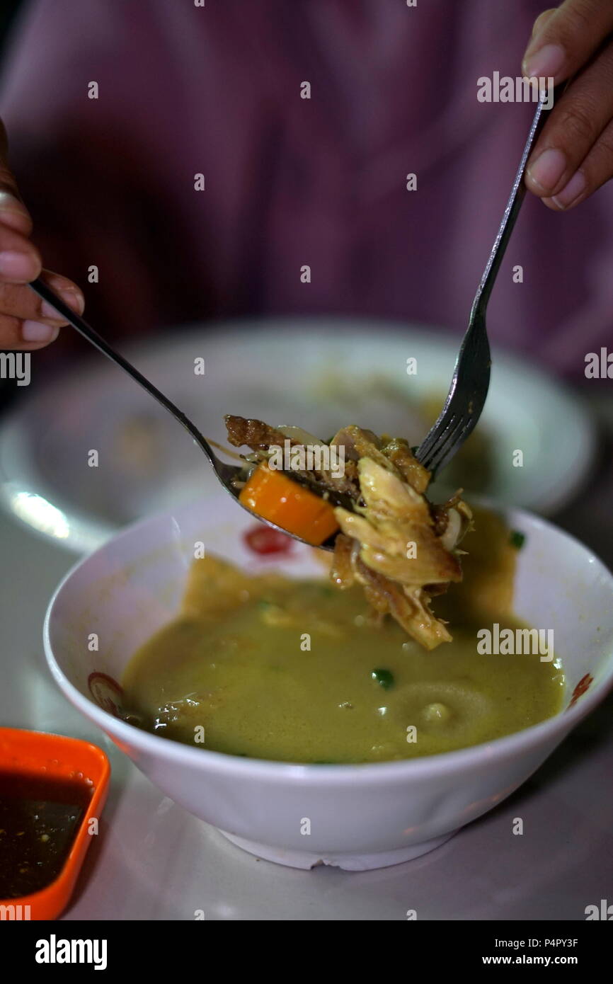 Delicious Nasi Soto, the Traditional Indonesian Food Served with Rice and Ice Tea Stock Photo