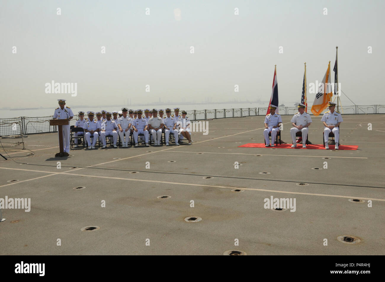 MINA SALMAN PIER, Bahrain (June 18, 2012) Members from the Combined Task Force (CTF) 151 staff  listen to a speech during a change of command ceremony aboard Royal Fleet Auxiliary (RFA) Fort Victoria (A387). Republic of Korea Navy Rear Adm. Anho Chung assumed command of CTF 151 from Royal Thai Navy Rear Adm. Tanin Likitawong. CTF 151 is a multi-national, mission based task force working under CMF, to conduct counter-piracy operations in the Southern Red Sea, Gulf of Aden, Somali Basin, Arabian Sea and Indian Ocean. Stock Photo