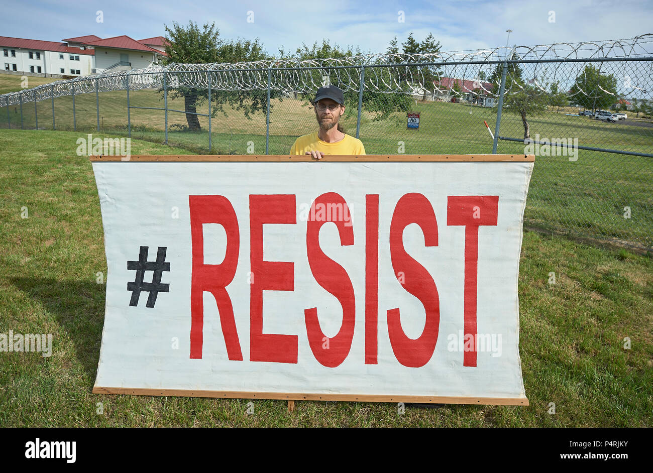 A man holds a sign during a rally outside a federal detention center in Sheridan, Oregon, protesting US government immigration policies. Stock Photo
