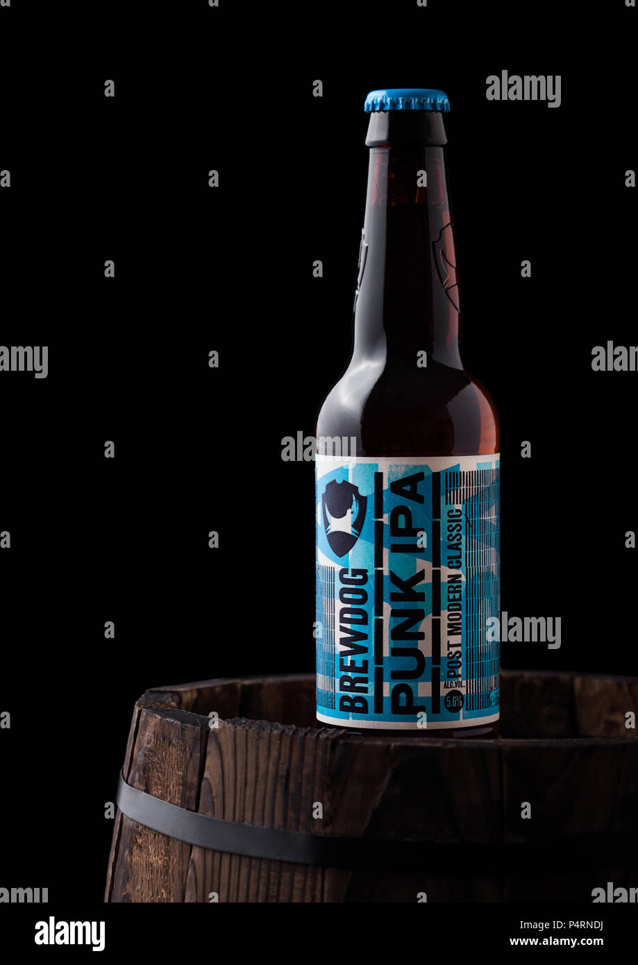 LONDON, UK - JUNE 06, 2018: Bottle of Punk IPA beer, from the Brewdog brewery on old wooden barrel on black background. Stock Photo