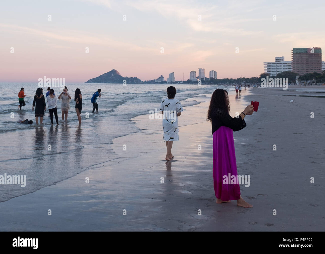 Female tourists taking pictures on the beach at evening, Prachuap Khiri Khan Province, Hua Hin, Thailand, Asia. Stock Photo