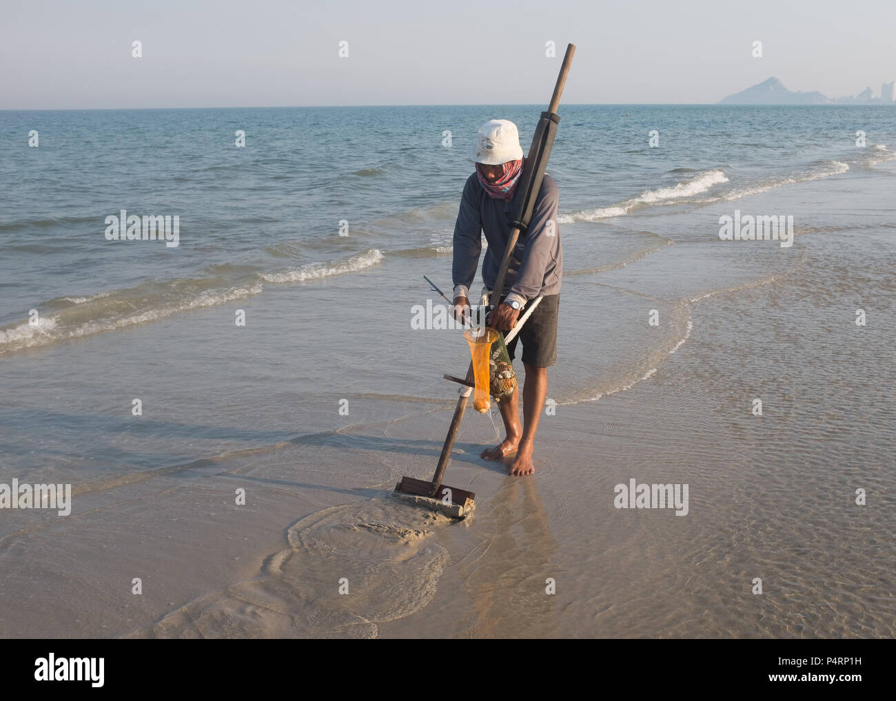 Man raking for clam shells on the beach, Prachuap Khiri Khan Province, Hua Hin, Thailand, Asia. Stock Photo