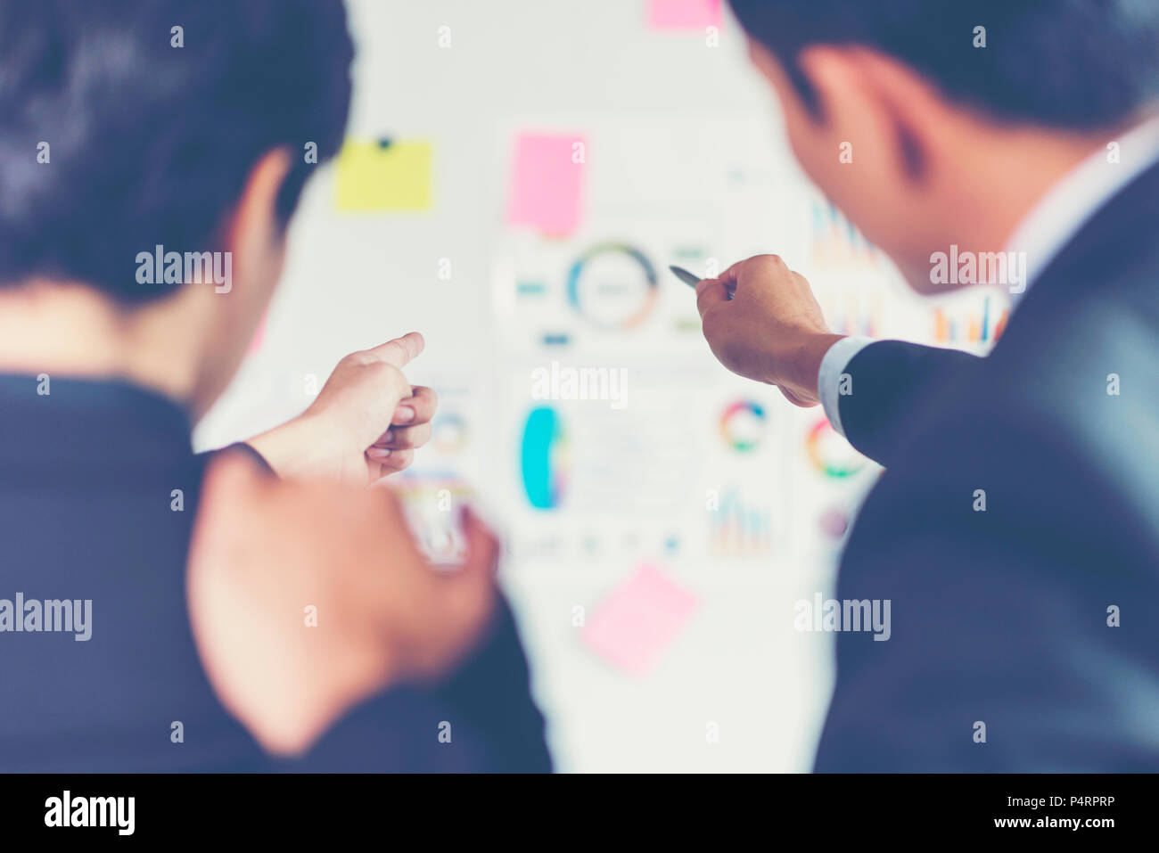 Hispanic businessman holding papers hands and smiling.Young team of coworkers making great business discussion in modern coworking office.Teamwork peo Stock Photo