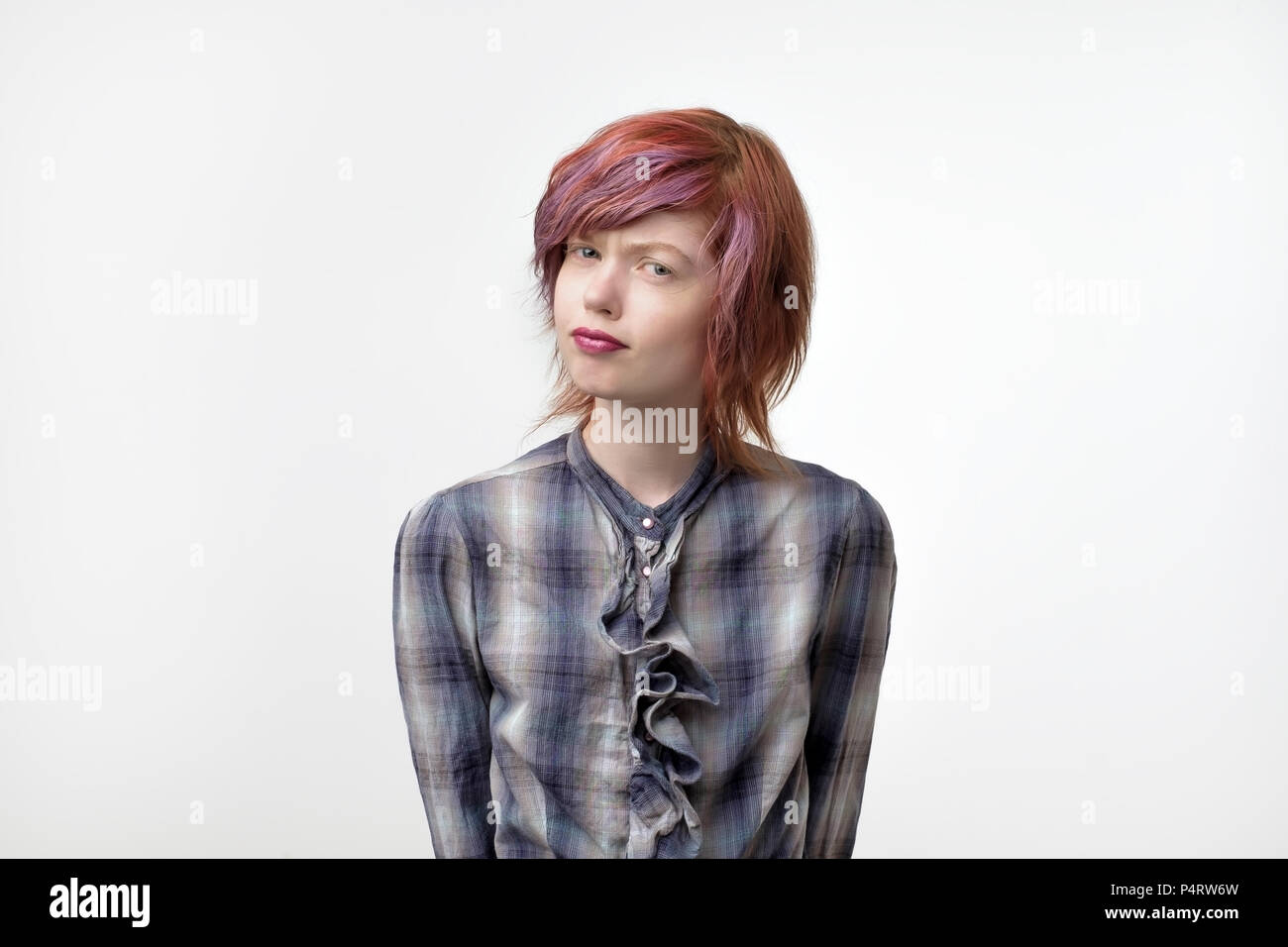 Portrait of unusual informal pretty woman with colorful hairstyle is with doubt in camera. Do not trust words. Stock Photo