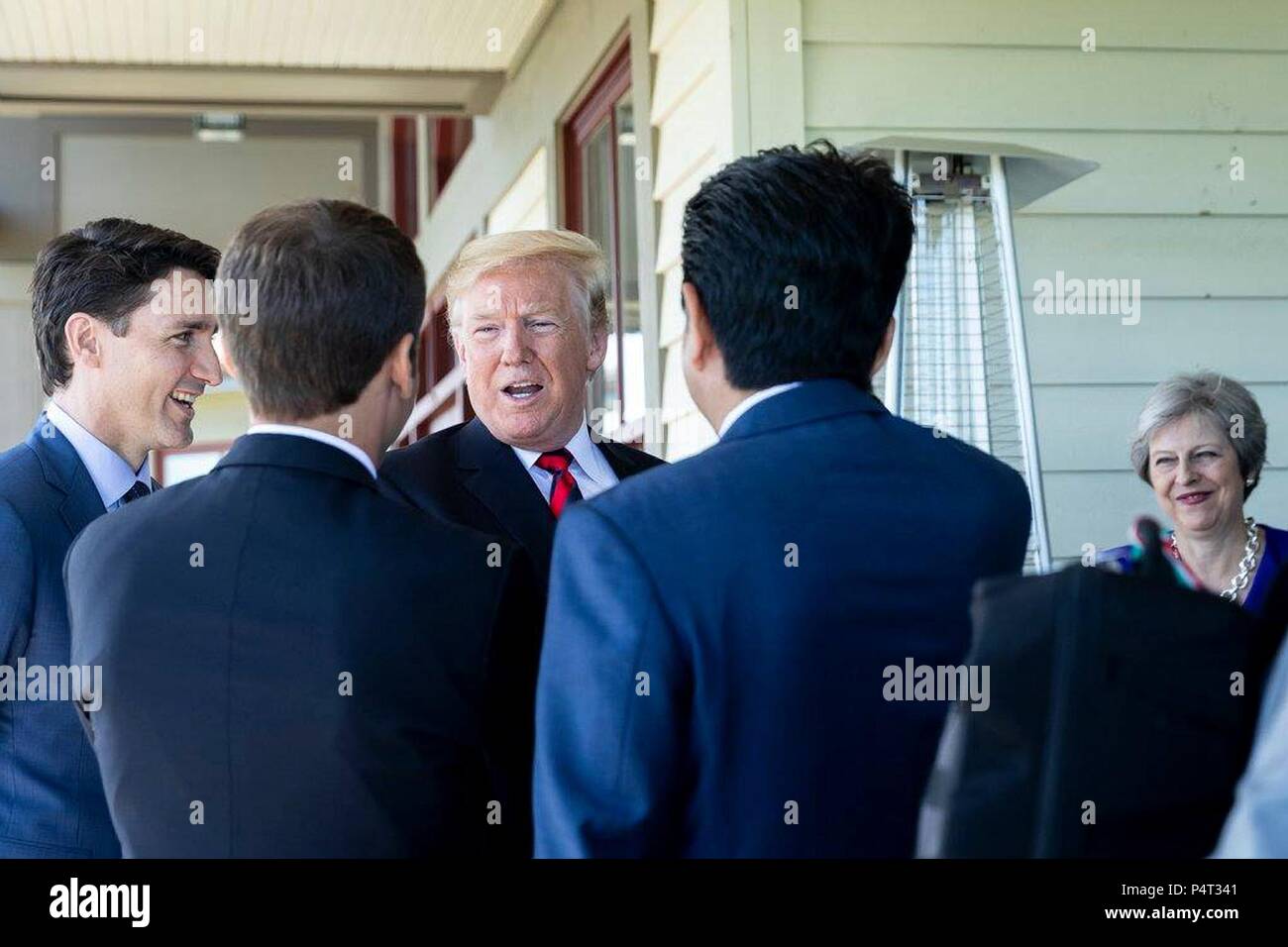 U.S. President Donald Trump, center, chats with Canadian Prime Minister Justin Trudeau, left, French President Emmanuel Macron, Japanese Prime Minister Shinzo Abe and British Prime Minister Theresa May, right, during a working lunch at the G7 Summit June 8, 2018 in Charlevoix, Quebec, Canada. Stock Photo