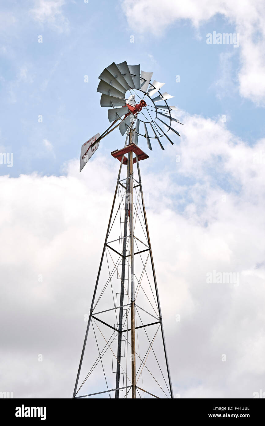 Old farm or ranch windmill water pump pumping water for agriculture in rural Alabama, USA . Stock Photo