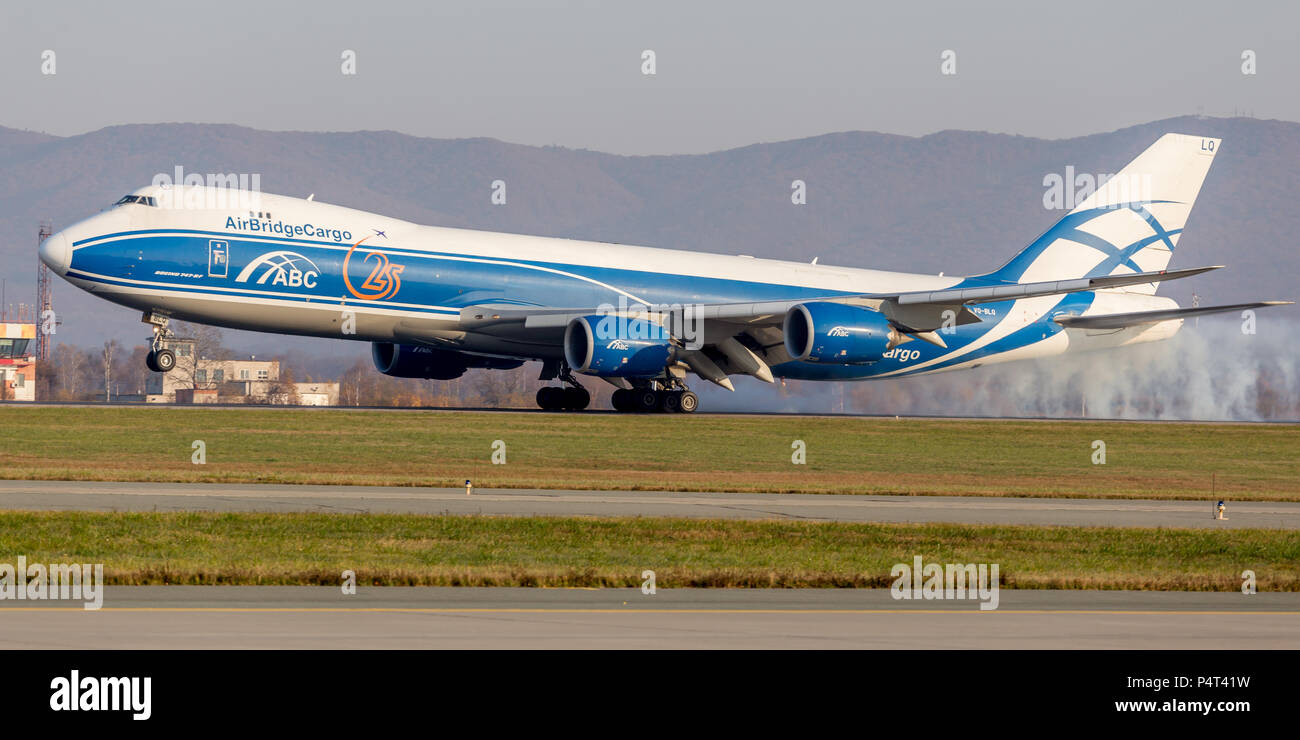 Russia, Vladivostok, 10/13/2017. Cargo jet aircraft Boeing 747-BF of AirBridgeCargo Airlines is landing with smoke under chasis. Aviation and transpor Stock Photo