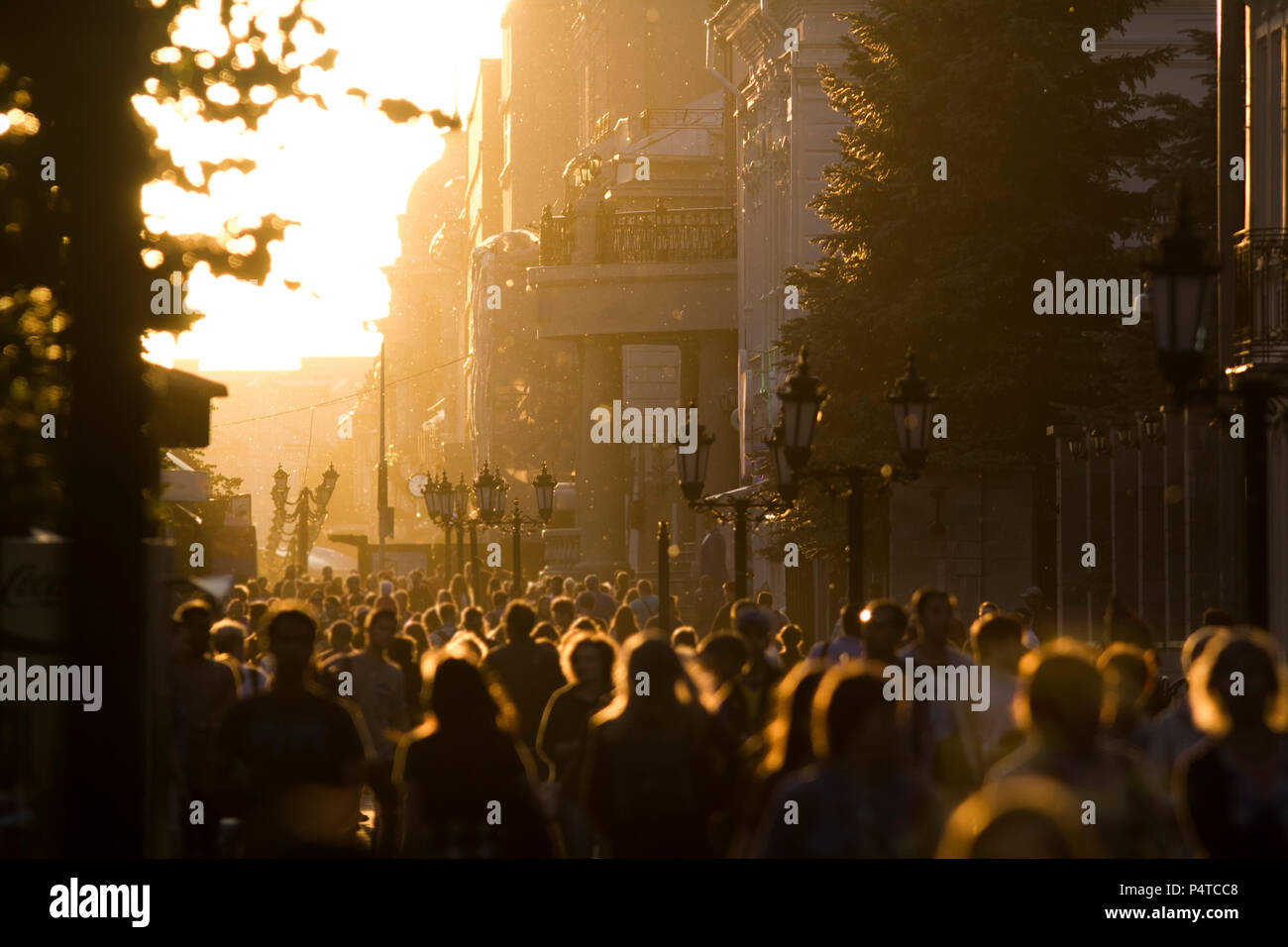 Silhouette crowd of people walking down the street at summer sunset ...