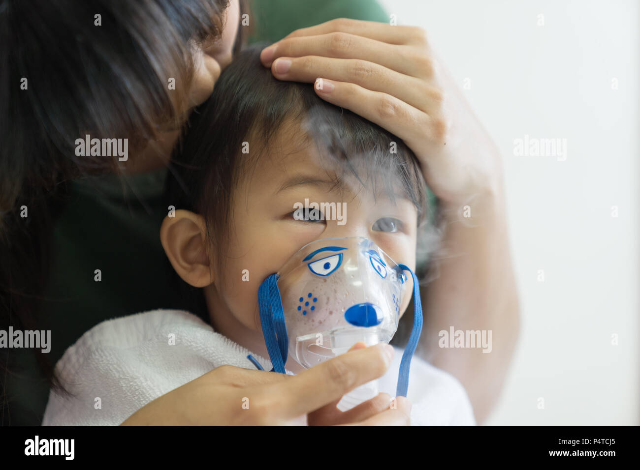 Asian baby girl breathing treatment with mother take care, at room