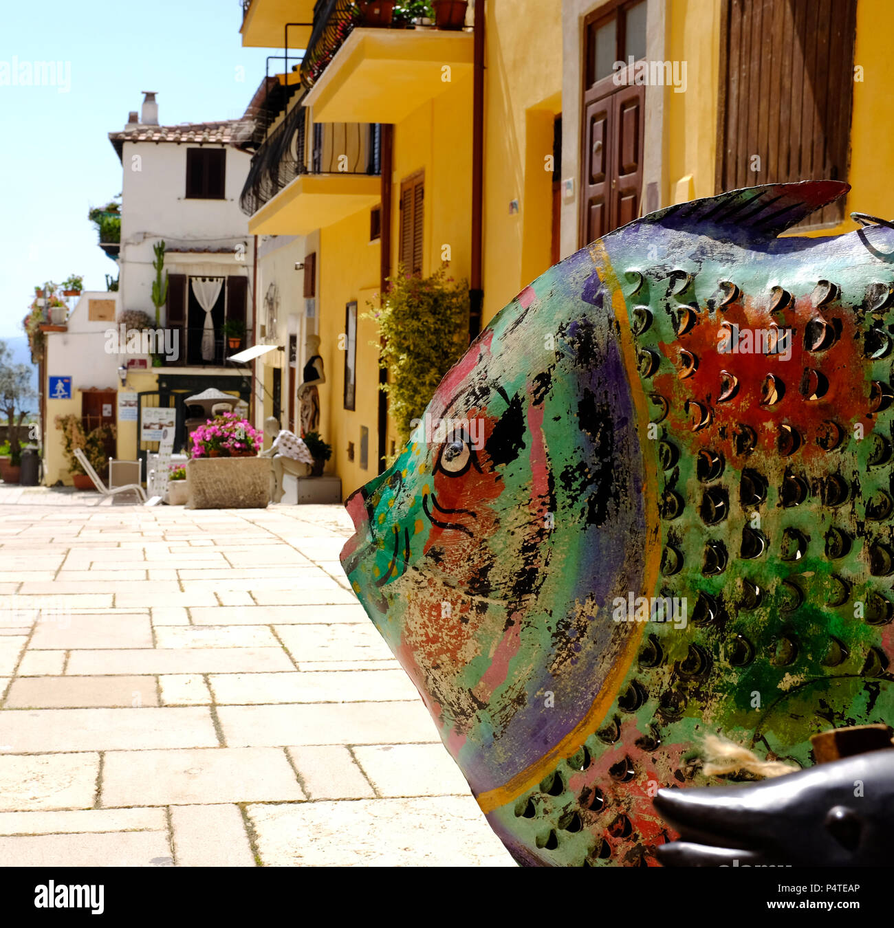 Metal fish in foreground for sale in front of a store. Taken in San Felice Circeo, a typical seaside village in Lazio in Italy Stock Photo