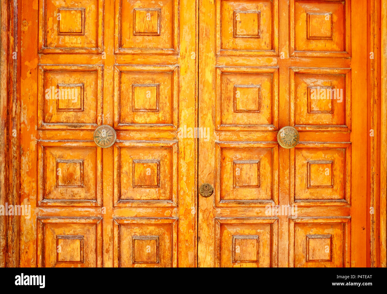 Old and aged historic door in ocher wood in the city of San Felice Circeo (seaside), Lazio, Italy Stock Photo