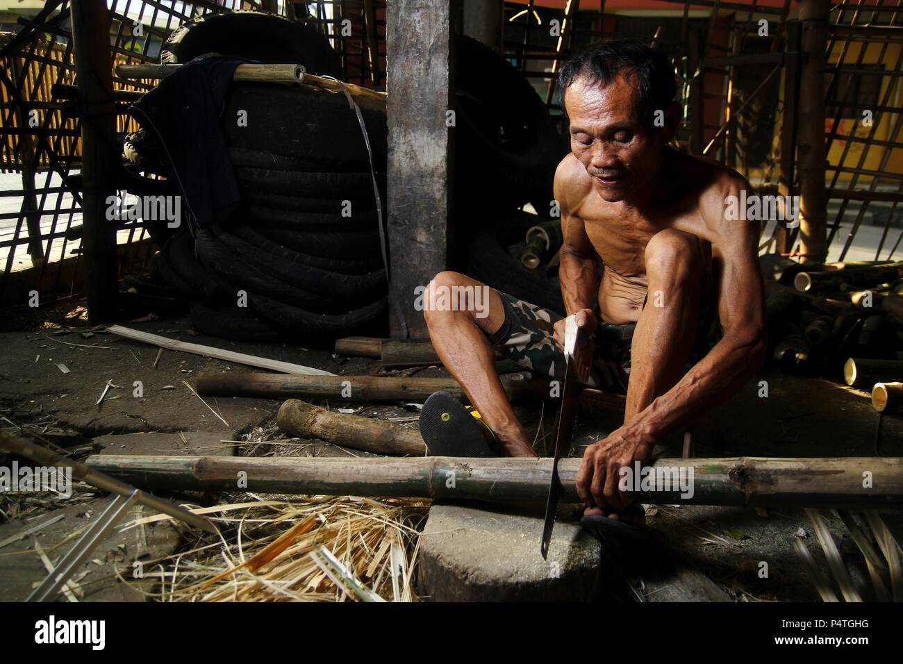 Photo of a bamboo furniture maker cutting bamboo Stock Photo Alamy