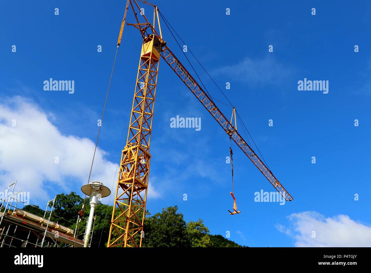 Bright orange crane with cabin on blue sky background in germany. Stock Photo