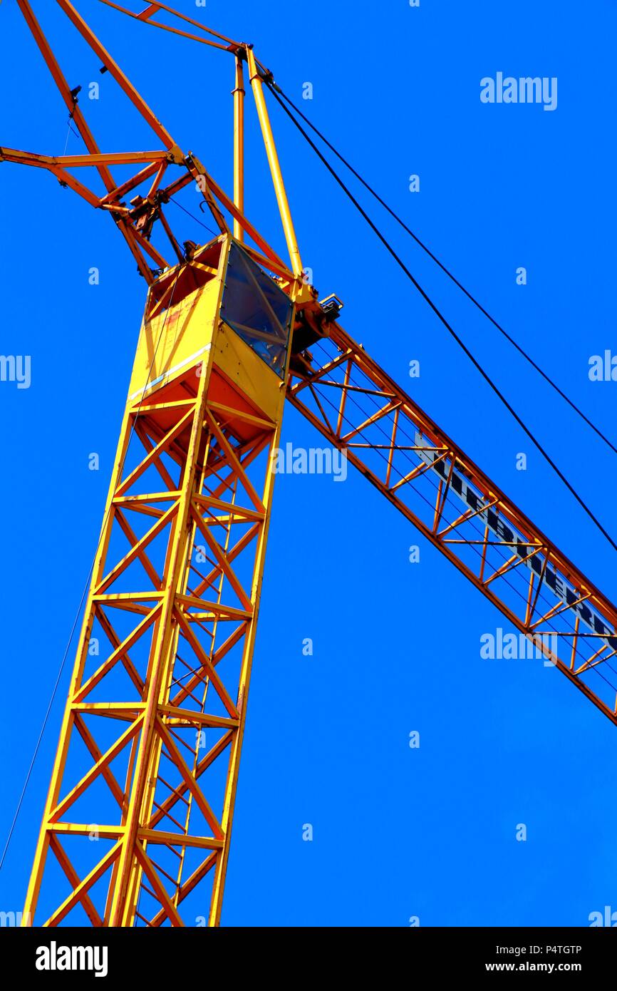 Bright orange crane with cabin on blue sky background in germany. Stock Photo