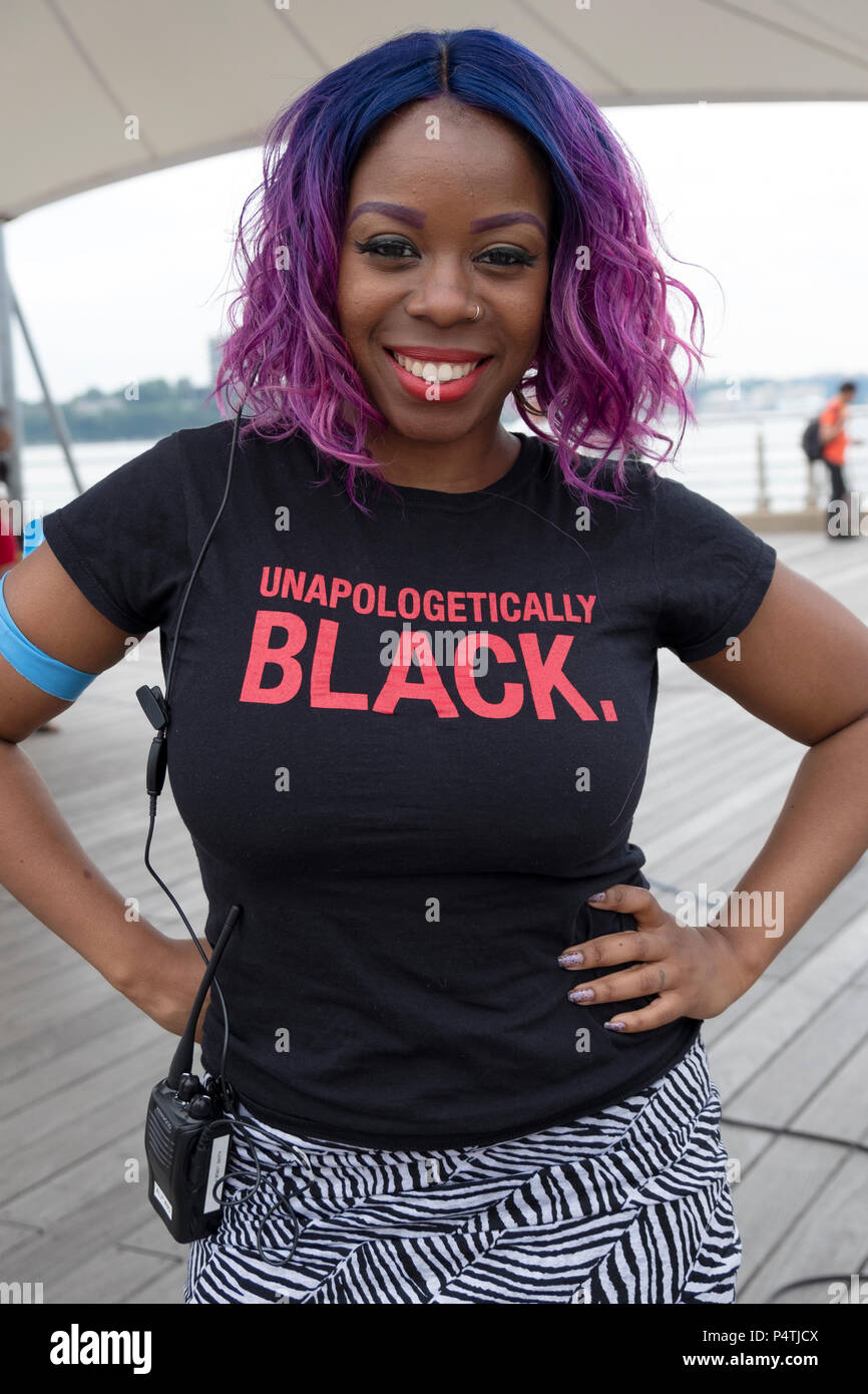 Posed portrait of a security guard at a rally wearing a tee shirt that says UNAPOLOGETICALLY BLACK. In Greenwich Village in New York City. Stock Photo