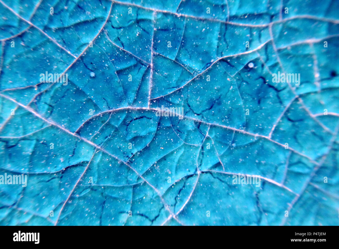 Macro of blurry cyan blue cracked ceramik tile surface. Stock Photo