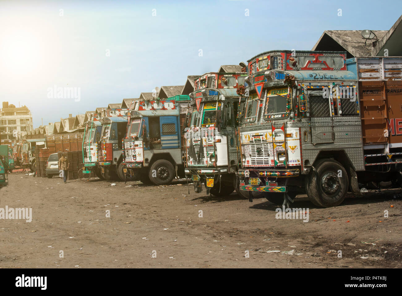 Colorful Indian heavy goods vehicles parked up at delhi (Indian truck stop) in the mid day sun Stock Photo