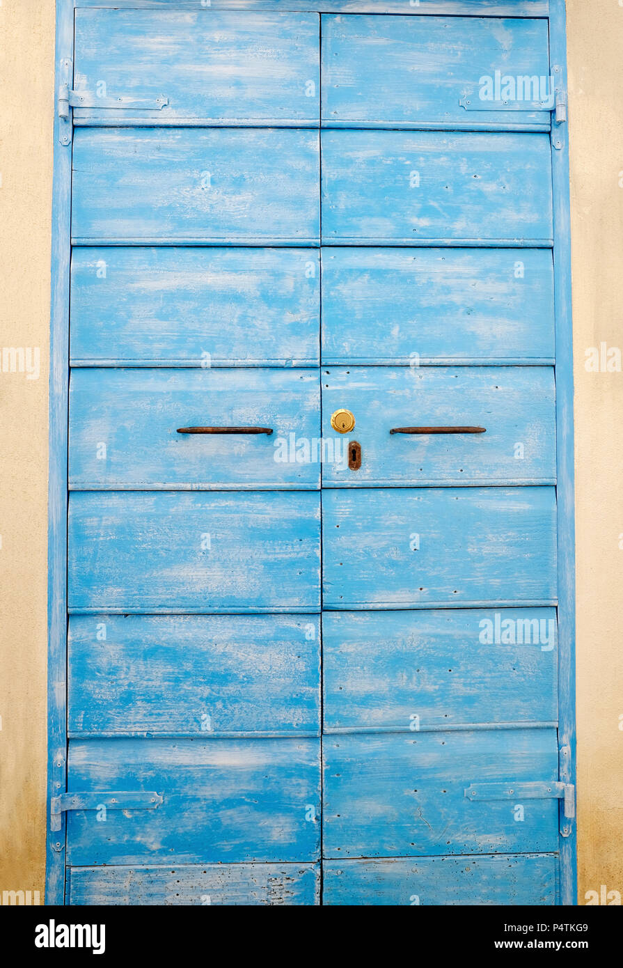 Old and aged historic door in blue wood in the city of San Felice Circeo (seaside), Lazio, Italy Stock Photo