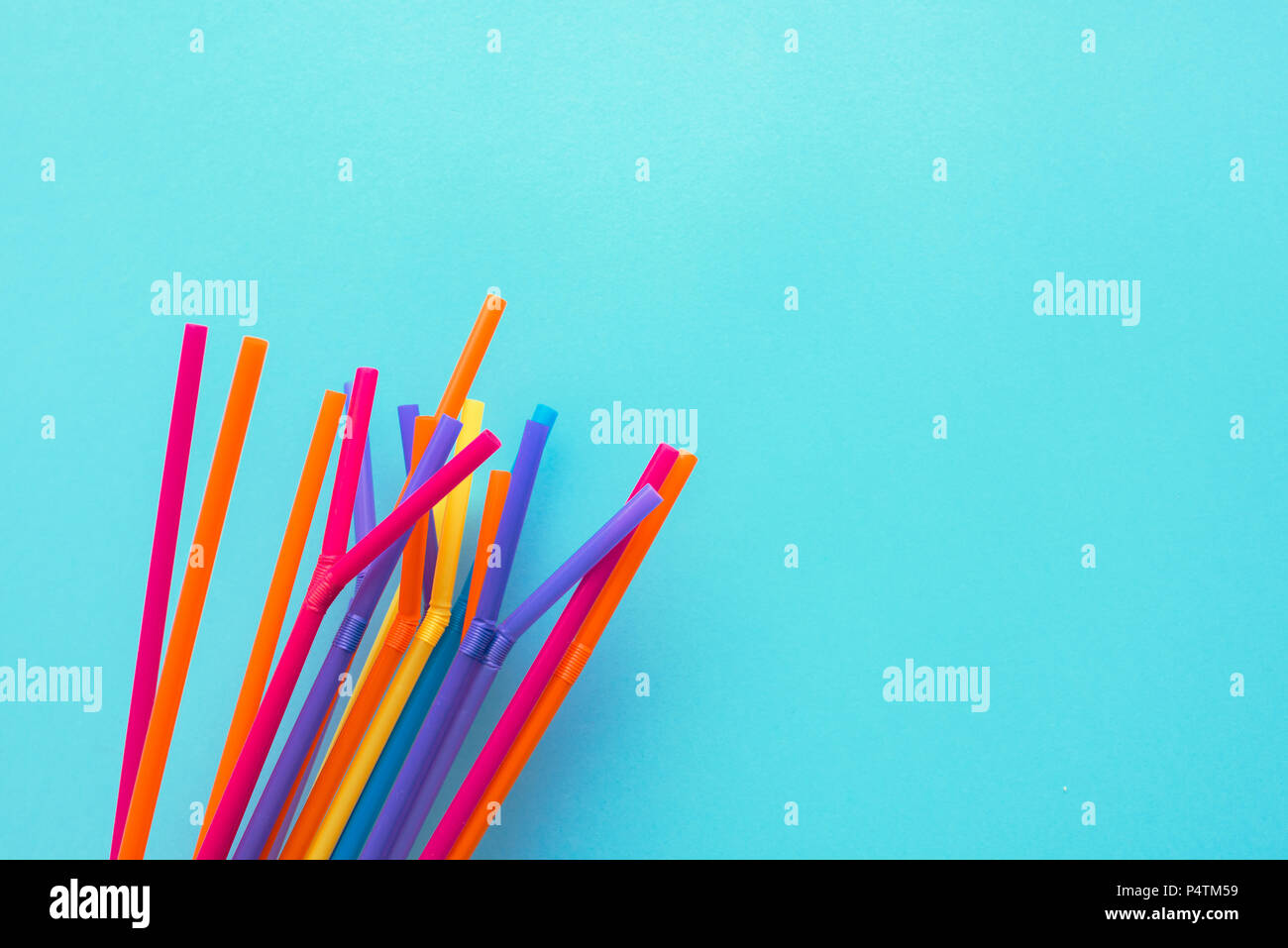 Summer season background, colorful drinking straws on blue backdrop with copy space Stock Photo