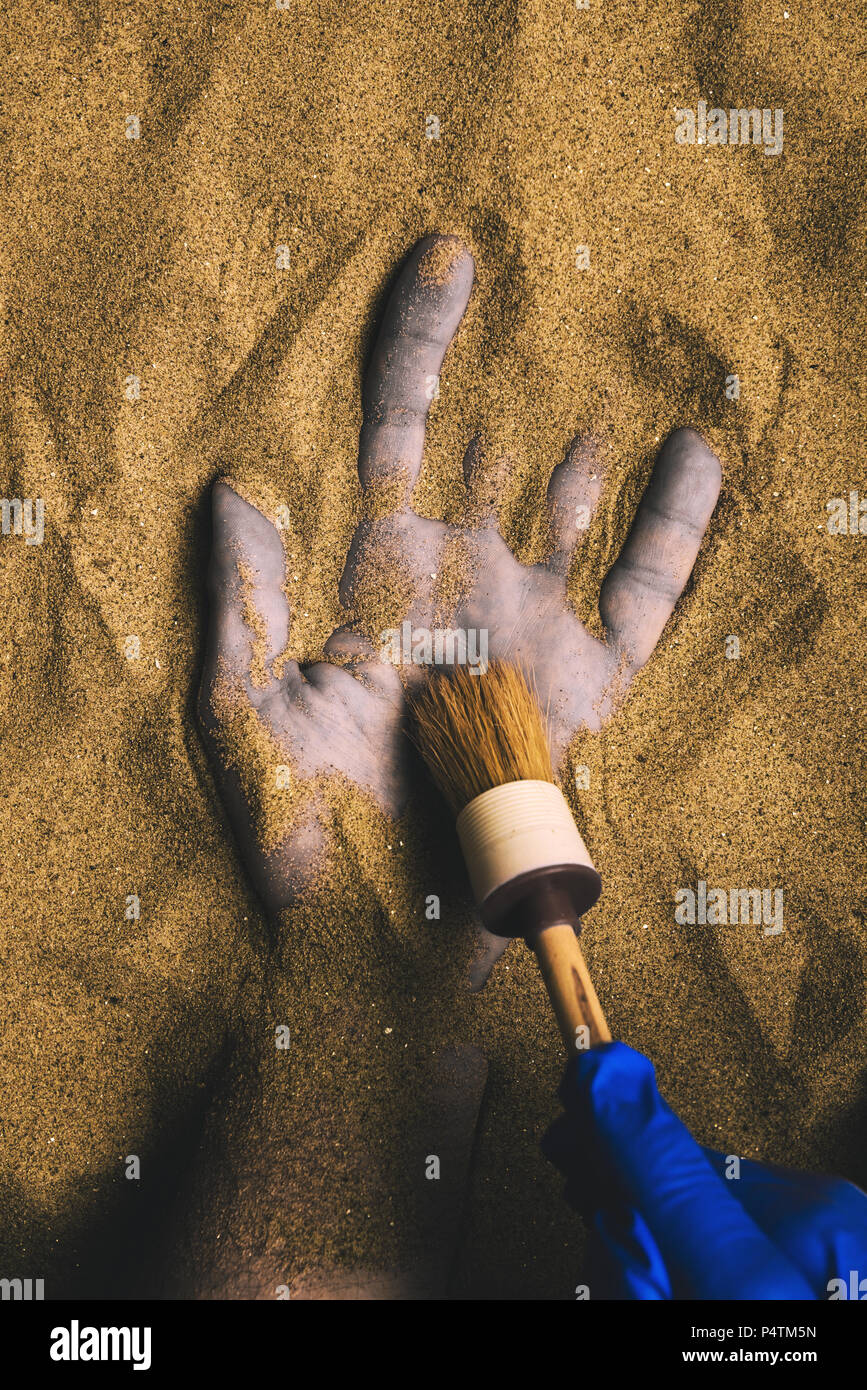 Forensic expert discovering dead body buried in desert sand. Conceptual image for police investigation of an cold case murder crime scene. Stock Photo