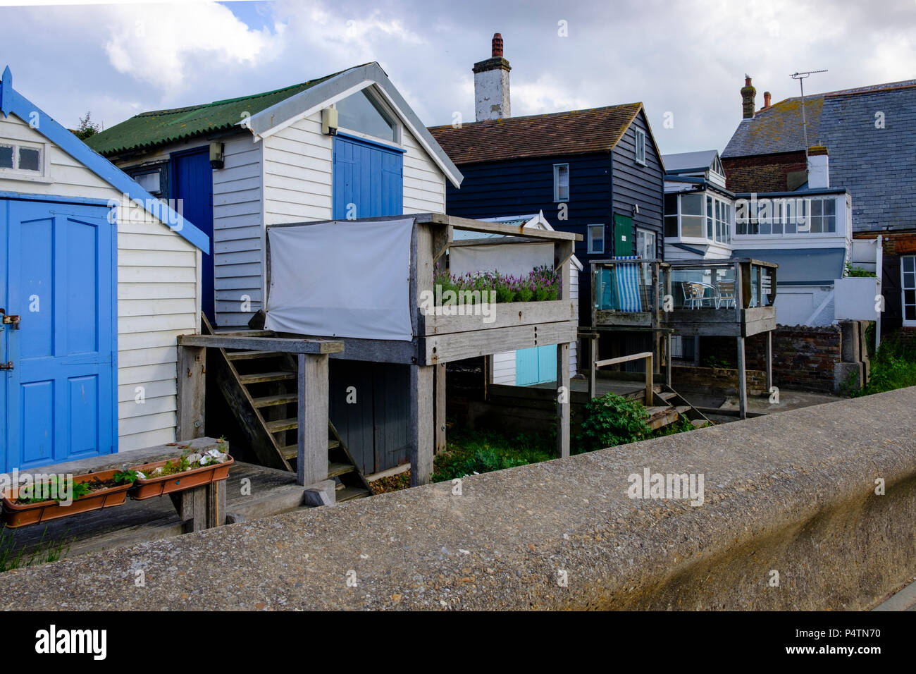 Timber clad seafront properties at Whitstable showing the protective sea wall Stock Photo Alamy