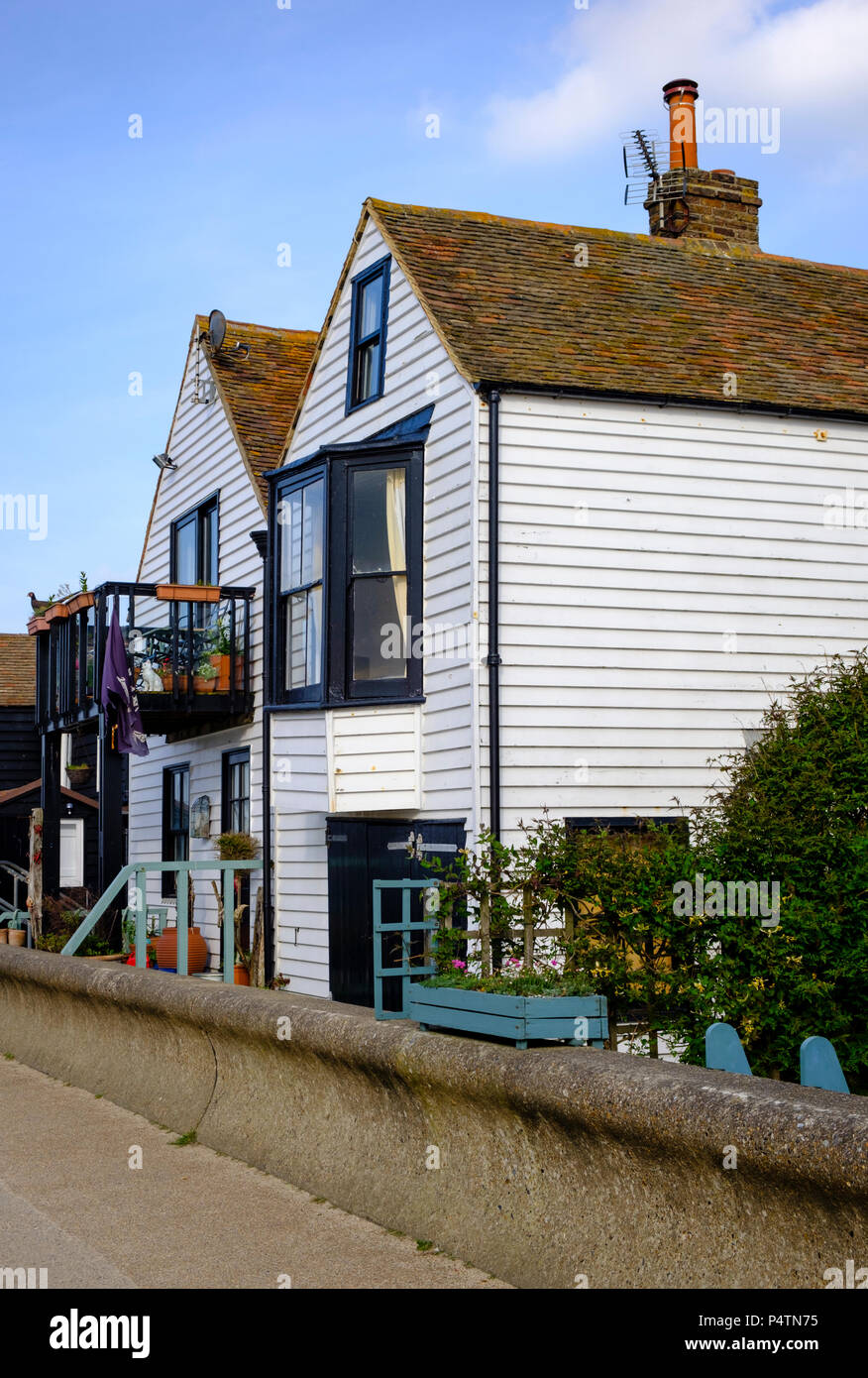 Timber clad seafront properties at Whitstable showing the protective sea wall Stock Photo Alamy