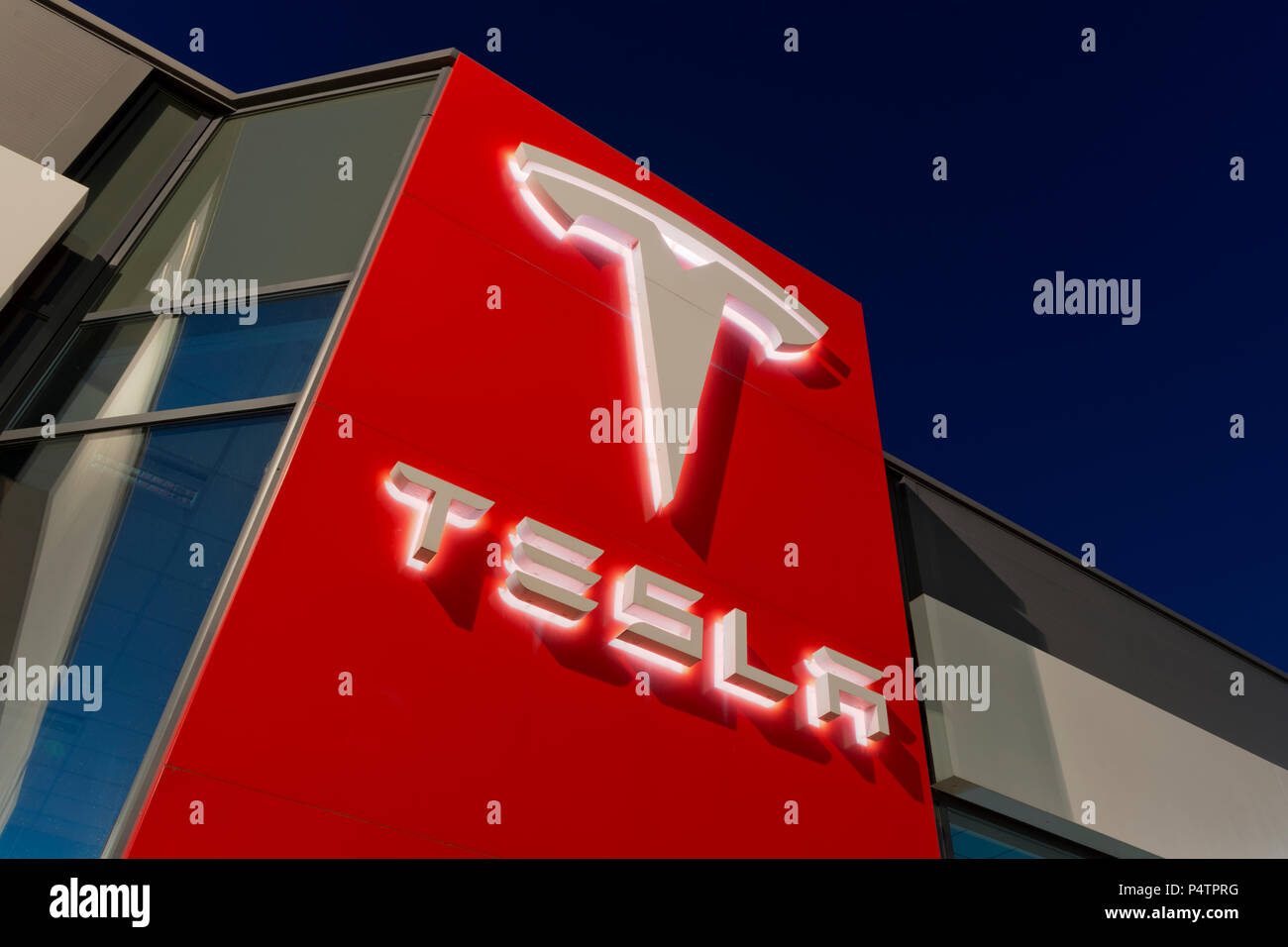 Signage for the Tesla motor company at nigtht outside one of its showrooms in South Manchester, UK. Stock Photo