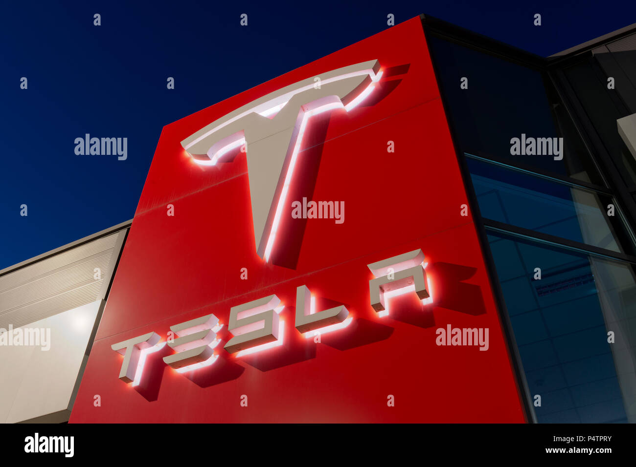 Signage for the Tesla motor company at nigtht outside one of its showrooms in South Manchester, UK. Stock Photo