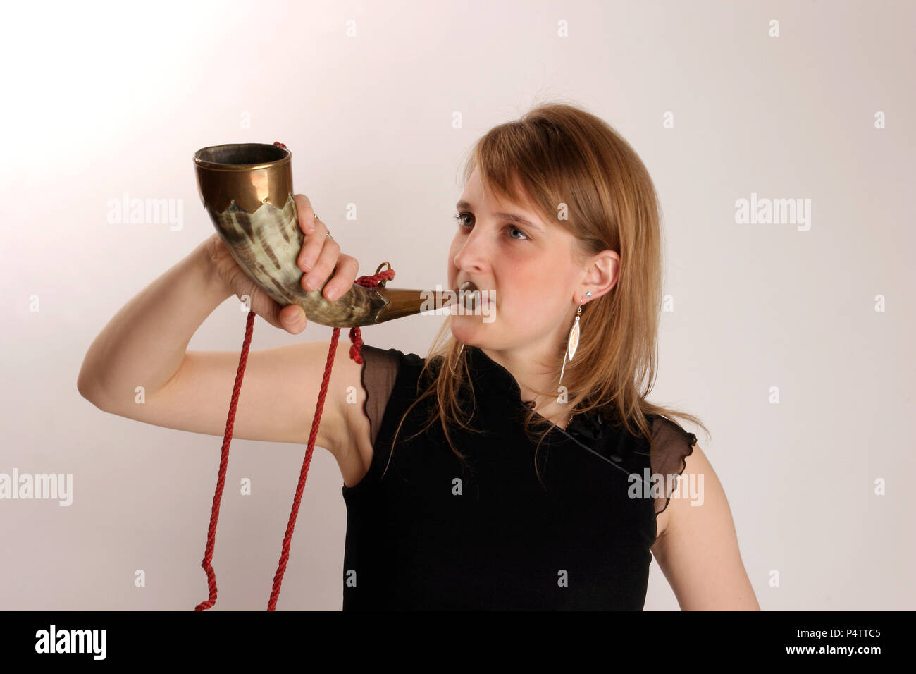 Cowhorn or natural animal horn. Being held in playing position. Brass