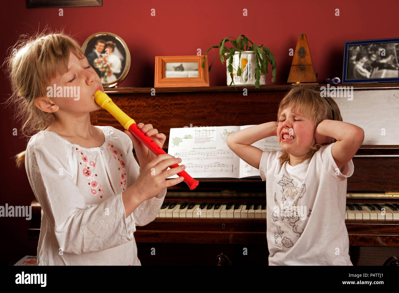 One girl playing the recorder and the other showing her appreciation Stock Photo
