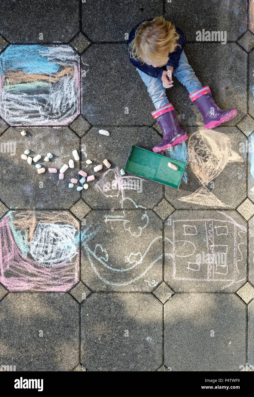 Little girl after drawing with chalk outdoors, top view Stock Photo