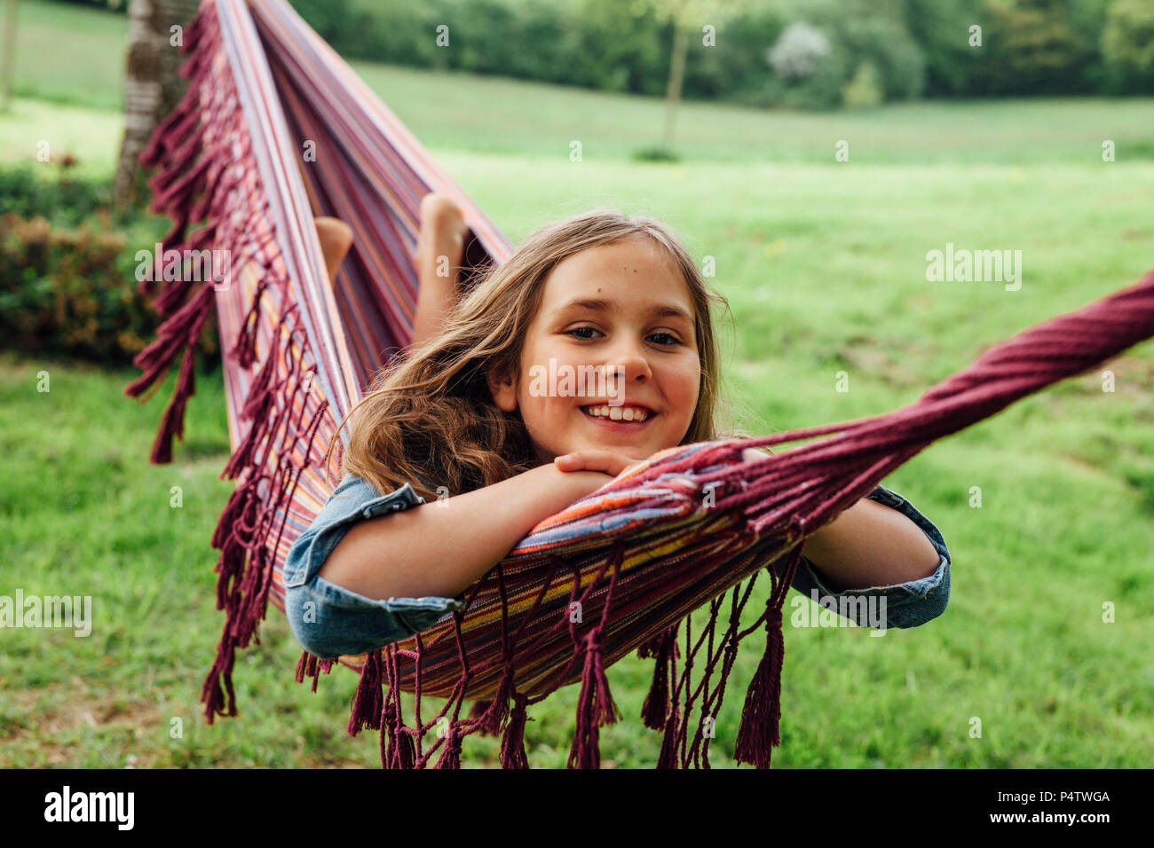 Portrait of happy girl lying in hammock Stock Photo - Alamy