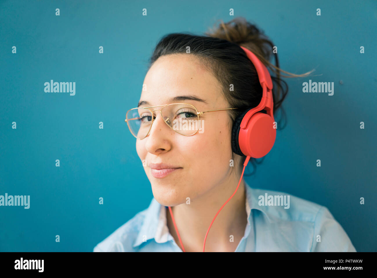 Portrait of smirking woman listening music with headphones Stock Photo