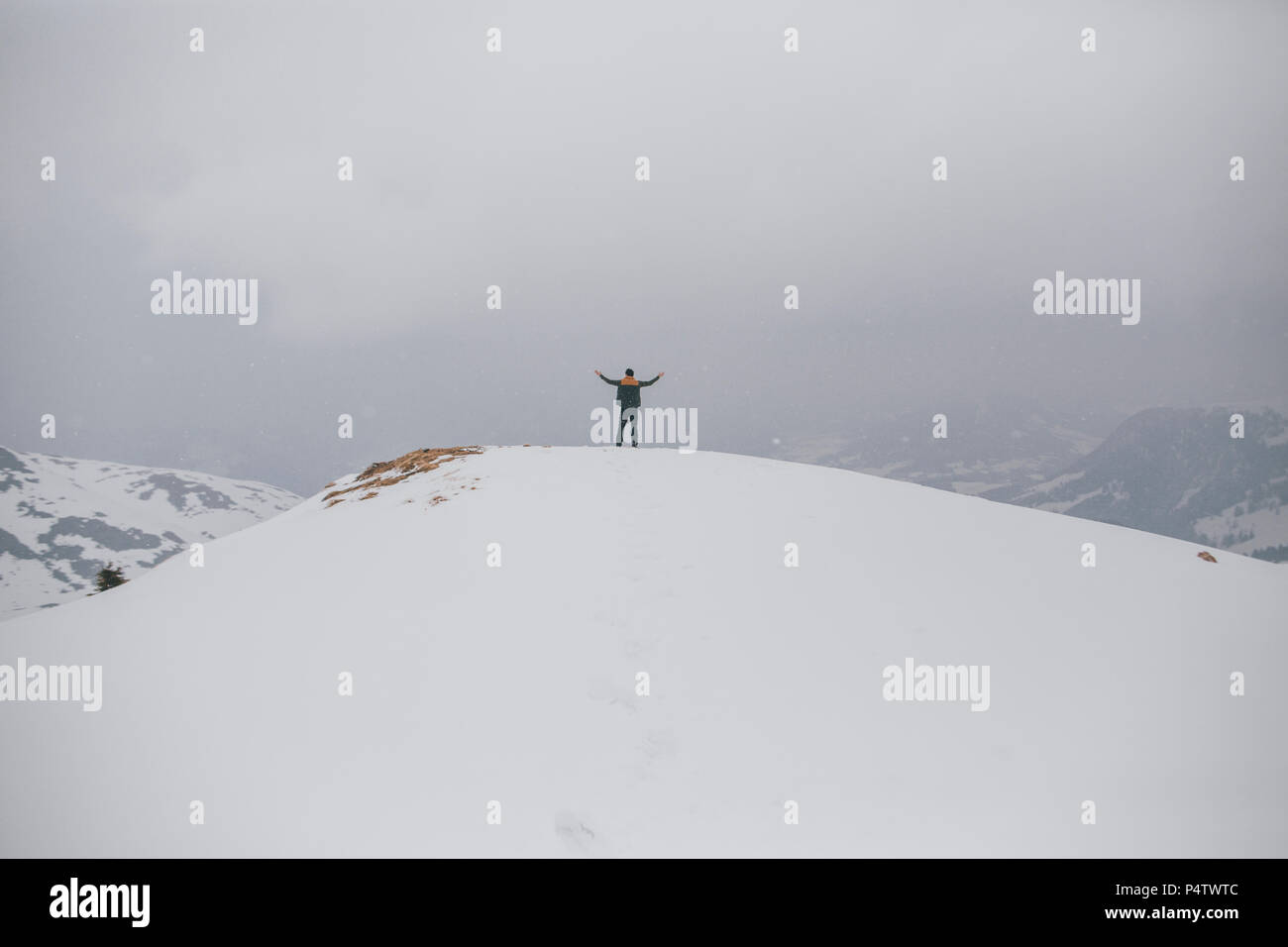 Austria, Kitzbuehel, back view of happy man enjoying snow-covered landscape Stock Photo