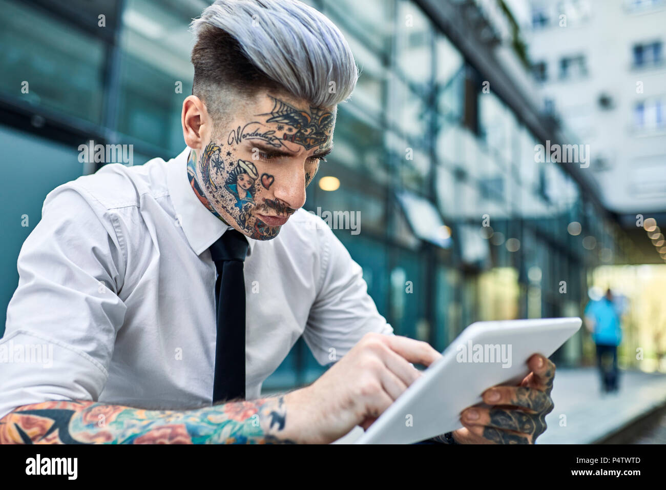 Portrait of young businessman with tattoos on his forearms stock photo