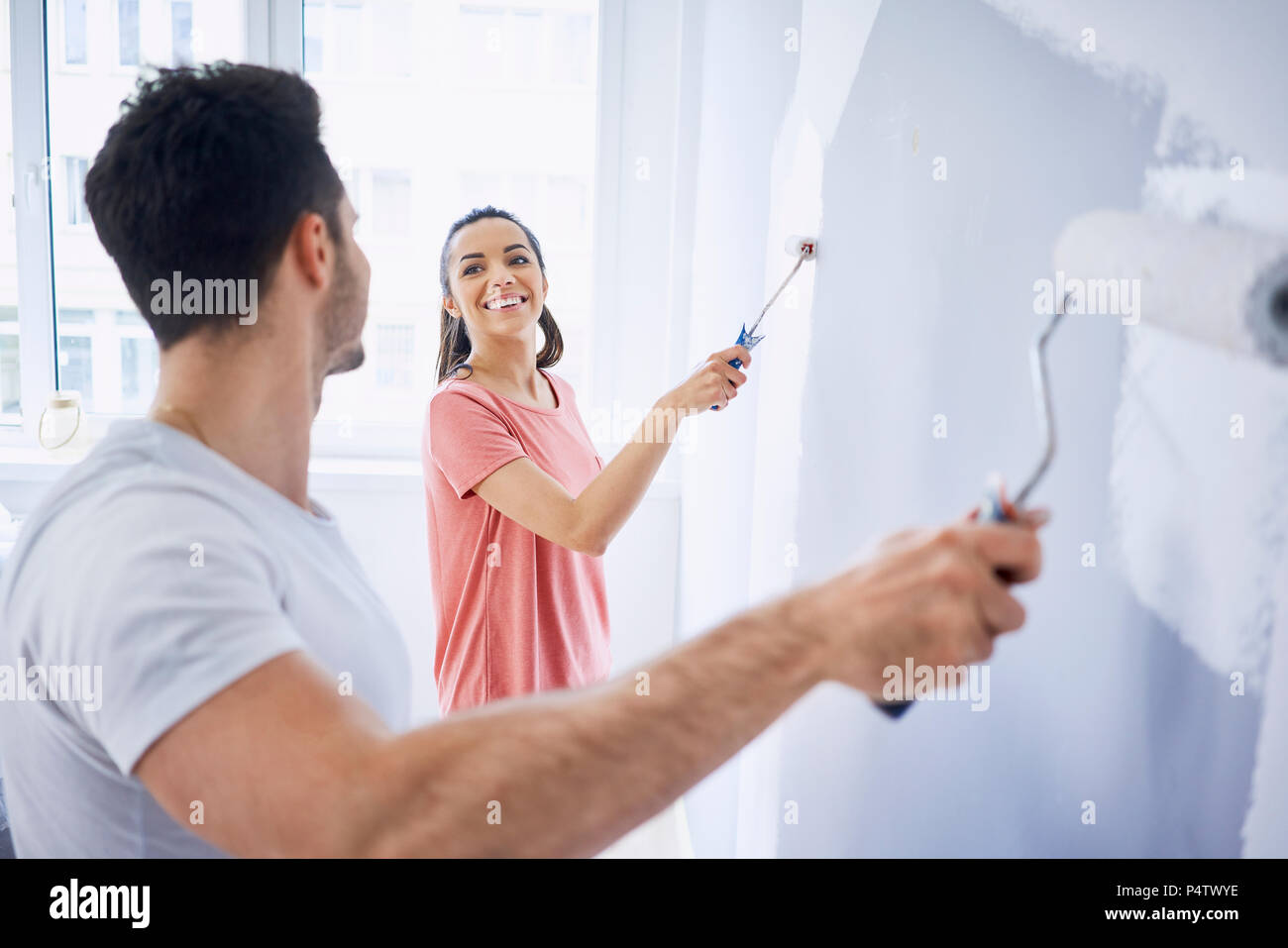 Happy couple painting wall in apartment together Stock Photo Alamy